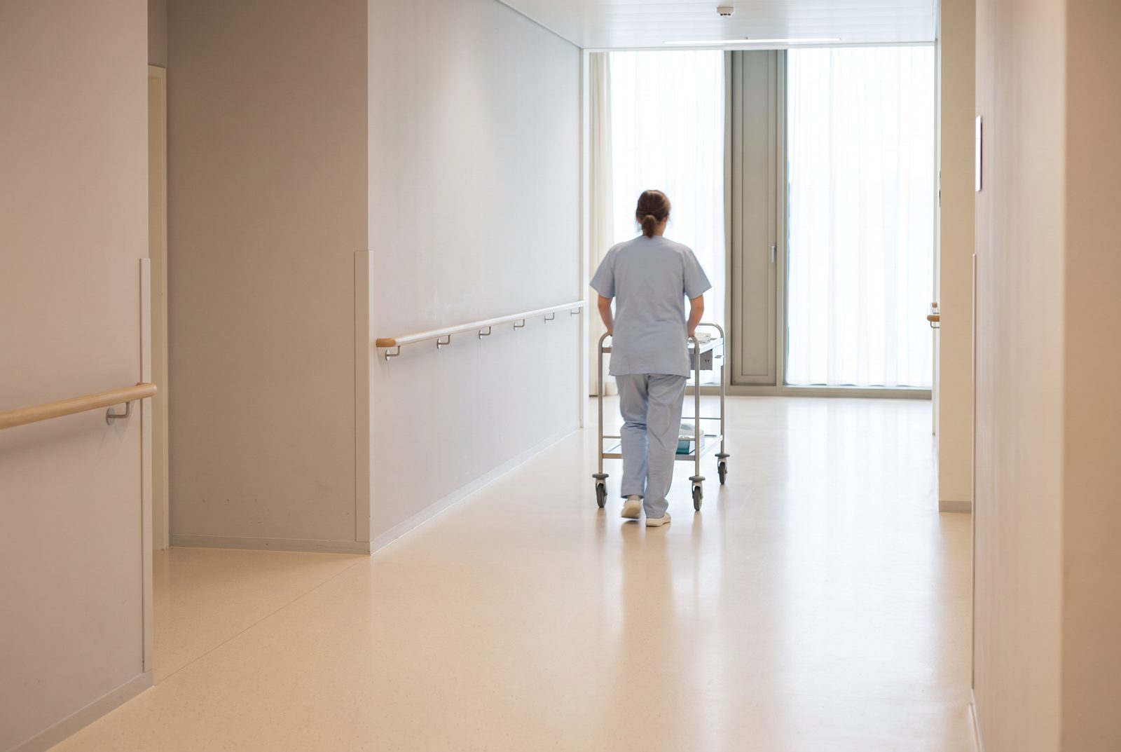 Pflegefachperson im Gespräch auf einem hellen Spitalgang