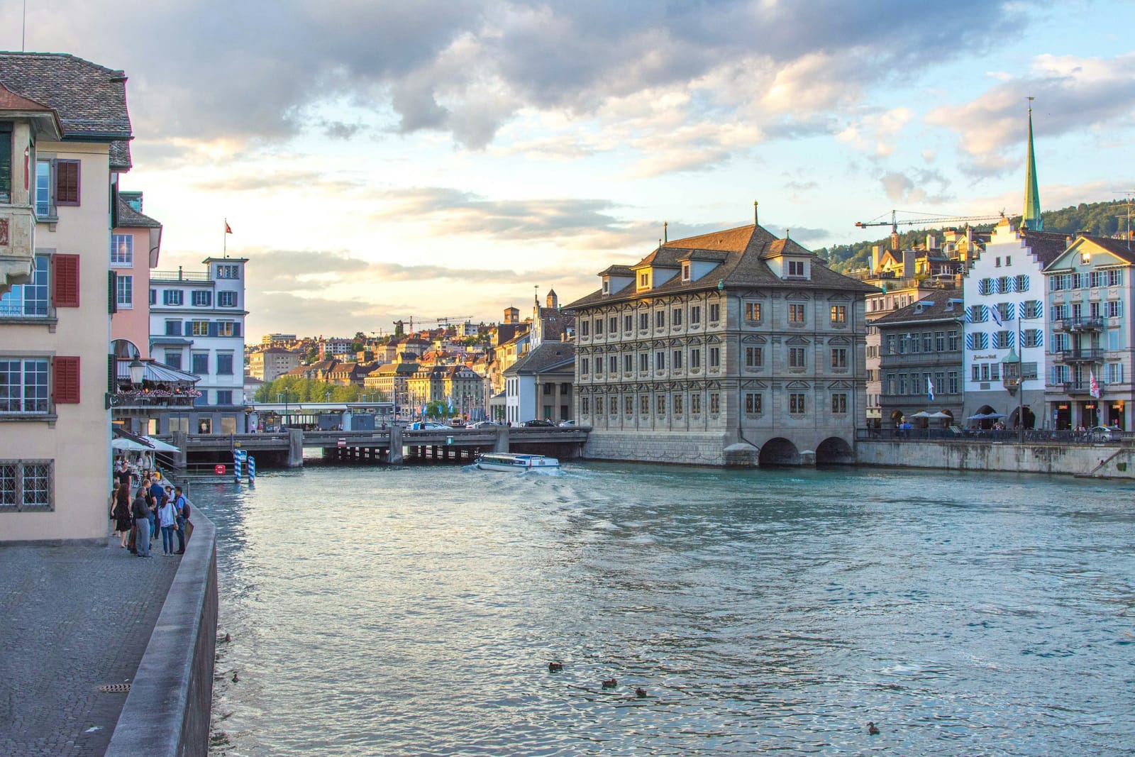 Abendlicht an der Limmat in Zürich, Menschen spazieren am Ufer